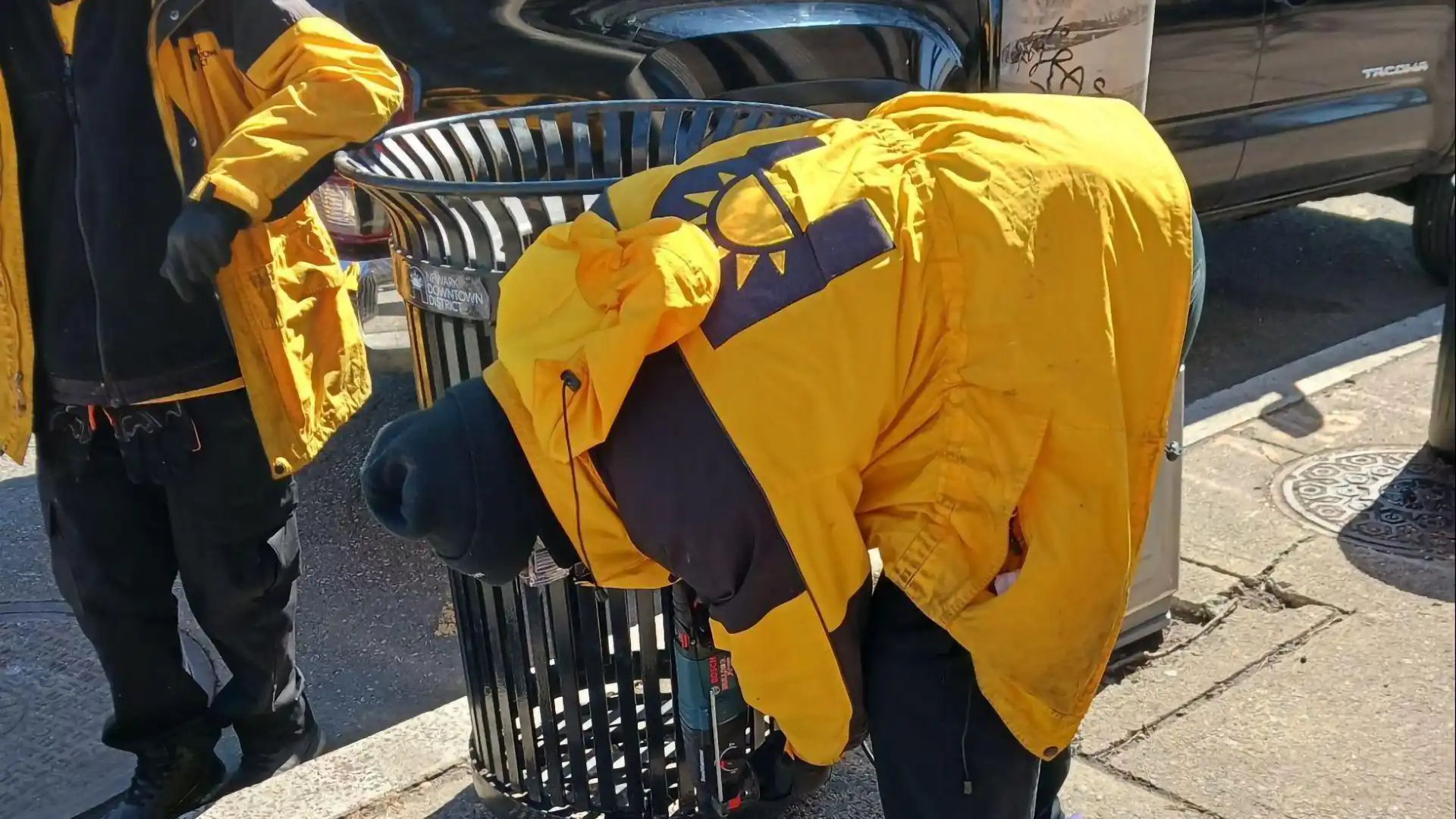 A maintenance crew repairing a garbage can.