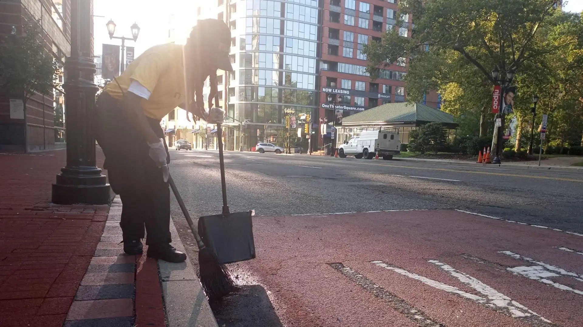 A maintenance worker sweeping the street.